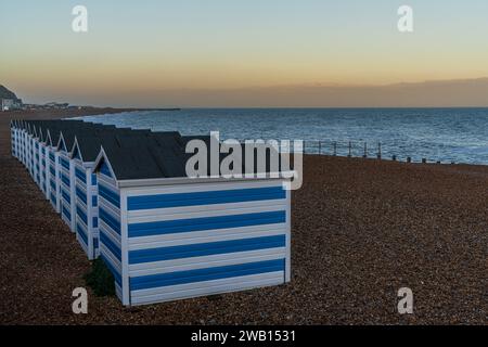Hastings, East Sussex, England, UK - 11. Mai 2022: Abendstimmung am Strand mit einigen Strandhütten Stockfoto