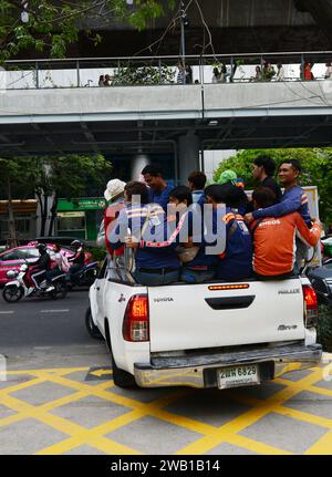 Ein Pickup-Truck voll beladen mit Personen, die hinten in Bangkok, Thailand, fahren. Stockfoto