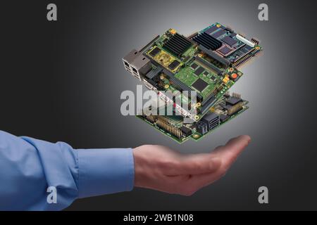 Schwebende industrielle, eingebettete CPU-Platinen über der Hand des Mannes auf grauem Hintergrund Stockfoto