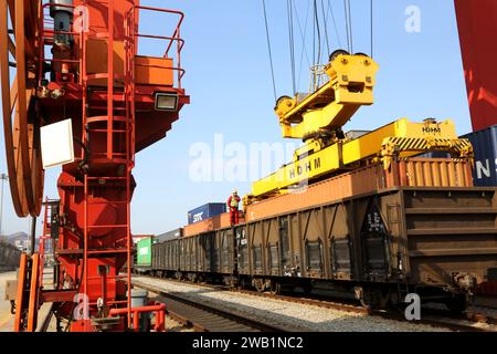 LIANYUNGANG, CHINA - 8. JANUAR 2024 - Großmaschinen beladen Container für den Güterzug China-Kasachstan (Lianyungang) auf der China-Kasachstan l Stockfoto