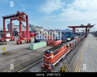 LIANYUNGANG, CHINA - 8. JANUAR 2024 - Großmaschinen beladen Container für den Güterzug China-Kasachstan (Lianyungang) auf der China-Kasachstan l Stockfoto