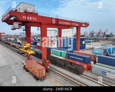 LIANYUNGANG, CHINA - 8. JANUAR 2024 - Großmaschinen beladen Container für den Güterzug China-Kasachstan (Lianyungang) auf der China-Kasachstan l Stockfoto