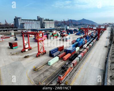 LIANYUNGANG, CHINA - 8. JANUAR 2024 - Großmaschinen beladen Container für den Güterzug China-Kasachstan (Lianyungang) auf der China-Kasachstan l Stockfoto