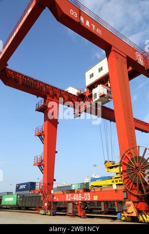 LIANYUNGANG, CHINA - 8. JANUAR 2024 - Großmaschinen beladen Container für den Güterzug China-Kasachstan (Lianyungang) auf der China-Kasachstan l Stockfoto