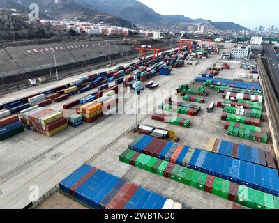 LIANYUNGANG, CHINA - 8. JANUAR 2024 - Großmaschinen beladen Container für den Güterzug China-Kasachstan (Lianyungang) auf der China-Kasachstan l Stockfoto