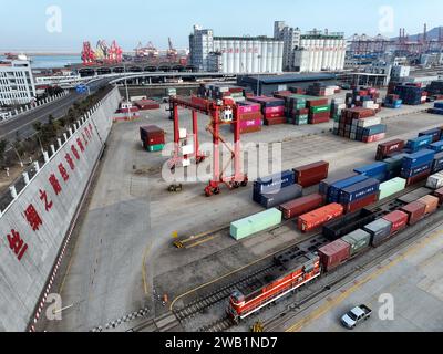 LIANYUNGANG, CHINA - 8. JANUAR 2024 - Großmaschinen beladen Container für den Güterzug China-Kasachstan (Lianyungang) auf der China-Kasachstan l Stockfoto