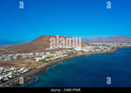 Playa Blanca Küste. Panoramablick der Drohne mit rotem Vulkan im Hintergrund. Tourismus- und Urlaubskonzept. Flamingo Beach Lanzarote, Canar Stockfoto