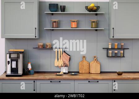 Moderne graue Kücheneinrichtung mit einigen Küchenutensilien. Selektiver Fokus. Stockfoto