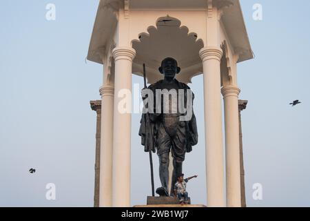 Kind am Fuße eines Mahatma Gandhi Monuments, Statue, ehemalige französische Kolonie Pondicherry oder Puducherry, Tamil Nadu, Indien Stockfoto