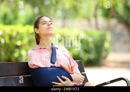 Rekonvaleszierende Frau, die frische Luft atmet, sitzt auf einer Bank im Park Stockfoto