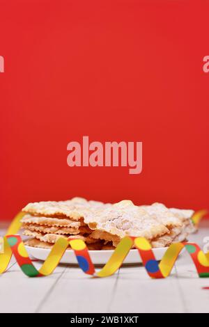 Gebratener italienischer Dessert-Snack für die Karnevalssaison namens 'Galani', 'Chiacchiere' oder 'Crostoli' vor rotem Hintergrund. Auch bekannt als Angel Wings PA Stockfoto