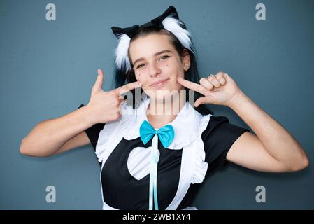 Eine kaukasische Cosplayer mit Katzenohren in einem japanischen Dienstmädchen-Outfit Stockfoto