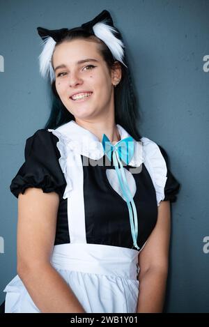 Eine kaukasische Cosplayer mit Katzenohren in einem japanischen Dienstmädchen-Outfit Stockfoto