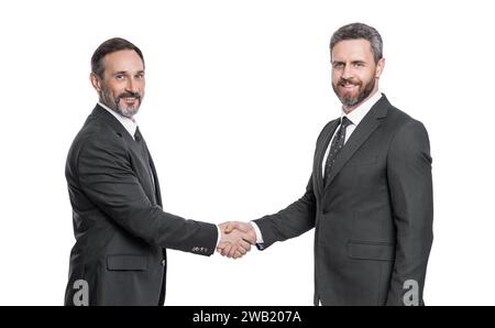 Lächelnde Geschäftsleute, die im Studio handeln. Geschäftsmänner, die mit Handschlag zu tun haben Stockfoto
