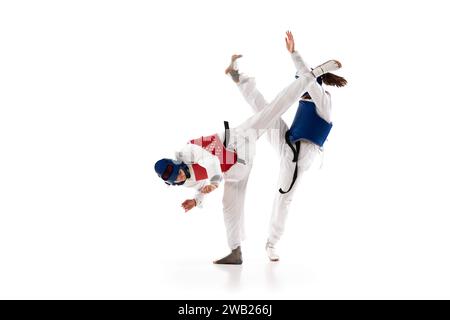 Zwei junge Mädchen im Dobok- und Helmtraining, üben Taekwondo-Posen, Haltungen isoliert über weißem Hintergrund Stockfoto