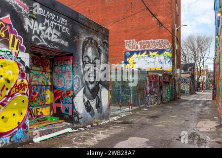 Die Graffiti Alley, auch bekannt als Rush Lane, ist ein verstecktes Juwel im Modeviertel von Toronto. Es ist eine enge Gasse, die von farbenfrohen Wandmalereien und Straßen gesäumt ist Stockfoto