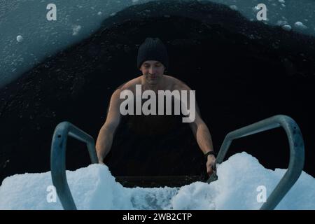 Ein Mensch atmet, während er ein gefrorenes Wasser in die Ostsee taucht Stockfoto