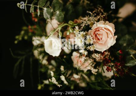 Blumenstrauß aus Rosen und kleinen zarten Blumen auf dunklem Hintergrund Stockfoto