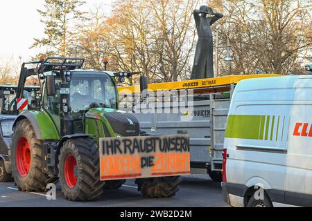 Berlin, Deutschland 08. Januar 2024: Bauernproteste in Berlin - Januar 2024 im Bild: Traktor mit Transparent Ihr raubt unseren Kindern die Zukunft, im Hintergrund die Skulptur der Rufer von Gerhard Marcks *** Berlin, Deutschland 08 Januar 2024 Bauernproteste in Berlin Januar 2024 im Bild Traktor mit Banner raubt man unseren Kindern ihre Zukunft, im Hintergrund die Skulptur der Anrufer von Gerhard Marcks Copyright: xFotostandx/xReuhlx Stockfoto