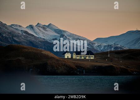 Altes Haus umgeben von Bergen bei Sonnenuntergang Stockfoto