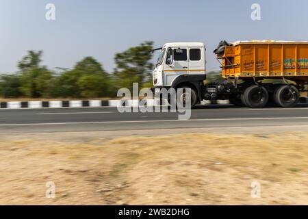 Ein Lkw, der an der Nationalstraße vorbeifährt, mit verschwommenem Hintergrund am Tag aus einem flachen Winkel wird am jodhpur udaipur National Highway rajasthan india On aufgenommen Stockfoto