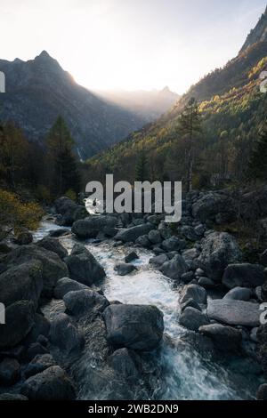 Alpenbach und Sonnenstrahlen im Val di Mello, Italien Stockfoto