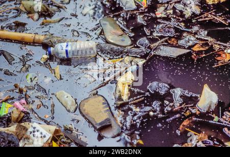 Indonesien, Jakarta - Hausschuhe aus Kunststoff, Flaschen und andere Abfälle in einem Fluss. Stockfoto