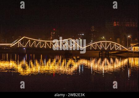 Die alte französische Brücke am Praek Tuek Chhu erleuchtete bei Nacht. Kampot, Kambodscha. © Kraig Stockfoto