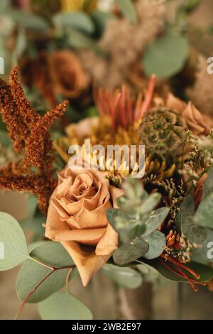 Nahaufnahme einer getrockneten Rose in einem herbstlich inspirierten Blumenarrangement Stockfoto