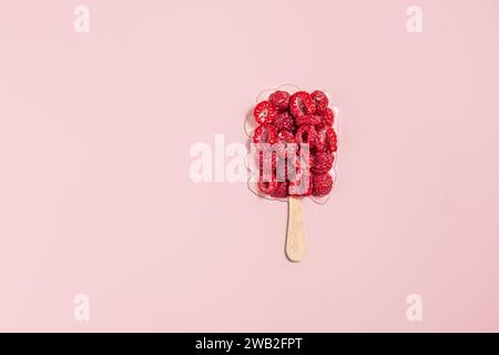 Himbeer-Popsicle-Form auf Rosa. Gesundes Sommerkonzept Stockfoto