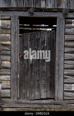 Sunja, Kroatien, 05.04.2021: Alte rustikale Holztür an ländlicher Hauswand. Stockfoto