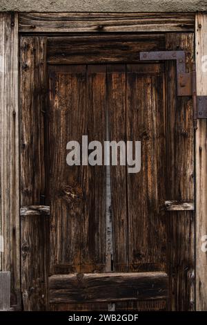 Sunja, Kroatien, 05.04.2021: Alte rustikale Holztür an ländlicher Hauswand. Stockfoto