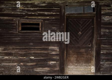 Sunja, Kroatien, 05.04.2021: Alte rustikale Holztür an ländlicher Hauswand. Stockfoto