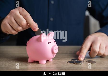 Legen Sie Pennys in eine Schweinebank. Einsparungen und Investitionen. Sammlung von Spenden. Bankeinzahlung. Sammle Geld für deinen Traum. Senken Sie die Kosten. Für Stilllegung speichern Stockfoto