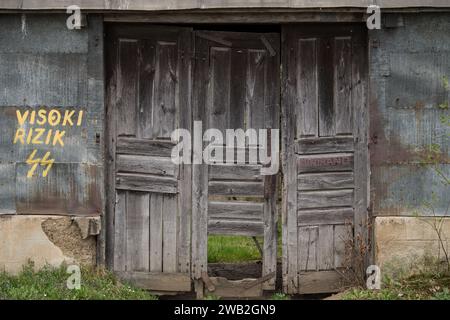 Sunja, Kroatien, 05.04.2021: Alte rustikale Holztür an ländlicher Hauswand. Stockfoto