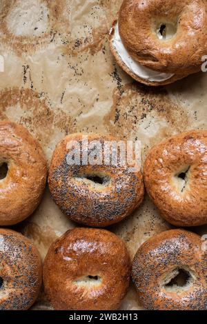 Mohnbagels mit Frischkäse auf Pergamentpapier Stockfoto