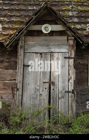 Sunja, Kroatien, 05.04.2021: Alte rustikale Holztür an ländlicher Hauswand. Stockfoto