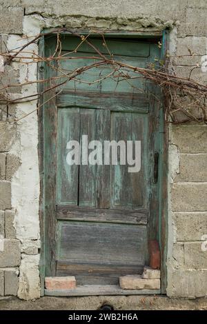 Sunja, Kroatien, 05.04.2021: Alte rustikale Holztür an ländlicher Hauswand. Stockfoto