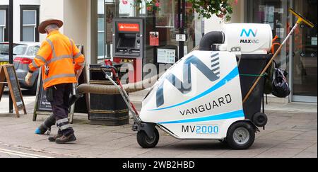 Vanguard Maxvac MV2000 Schweizer Design Urban Waste Saugmaschine Rückansicht Mann in Hut arbeitet Pavement Bury St Edmunds Suffolk England Großbritannien Stockfoto