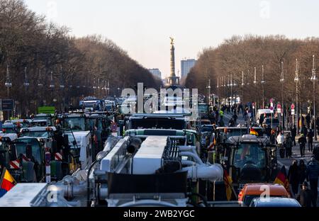 Berlin, Deutschland. Januar 2024. Traktoren und Lkw stehen auf der Straße des 17. Juni vor dem Hintergrund der Siegessäule. Als Reaktion auf die Sparpläne der Bundesregierung hat der Bauernverband eine Aktionswoche mit Kundgebungen und Kundgebungen ab dem 8. Januar gefordert. Am 15. Januar wird es in einer großen Demonstration in der Hauptstadt enden. Quelle: Monika Skolimowska/dpa/Alamy Live News Stockfoto