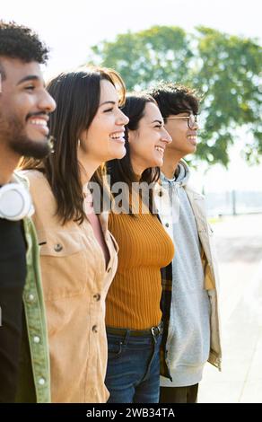 Seitenansicht der vereinigten multirassischen Menschen, die sich in Zusammenarbeit umarmen. Stockfoto