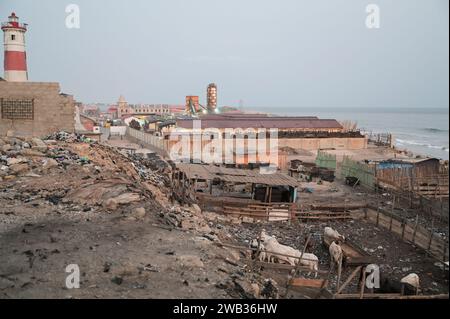 GHANA, Accra, Jamestown, Leuchtturm aus britischer Kolonialzeit und Viehfarm am atlantik, hinter Baustelle eines neuen Fischereihafens durch die chinesische Firma CRCC China Railway Construction Corporation Limited und China Aid / GHANA, Accra, Jamestown Leuchtturm aus der britischen Kolonialzeit, Kuhställe am Strand, hinten Baustelle eines neuen Fischerei Hafen durch chinesische Baufirma CRCC und China Aid Stockfoto