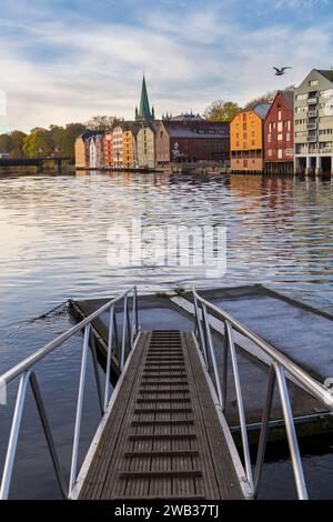 Farbenfrohe Lagerhäuser am Wasser, Werften Gebäude von Bakklandet auf Stelzen mit Reflexionen im Fluss Nidelva bei Trondheim, Norwegen, Skandinavien, Europa Stockfoto