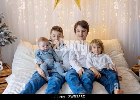 Glückliche Familie, neugeborenes Baby und ältere Brüder, Mutter zu Hause zu Weihnachten Stockfoto