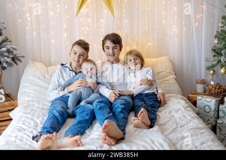Glückliche Familie, neugeborenes Baby und ältere Brüder, Mutter zu Hause zu Weihnachten Stockfoto