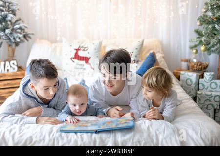 Glückliche Familie, neugeborenes Baby und ältere Brüder, Mutter zu Hause zu Weihnachten Stockfoto