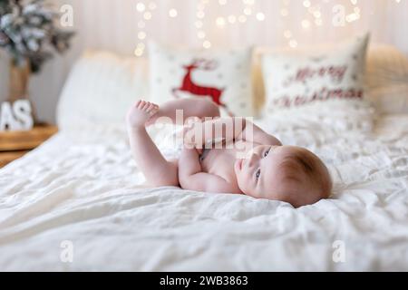 Glückliche Familie, neugeborenes Baby und ältere Brüder, Mutter zu Hause zu Weihnachten Stockfoto