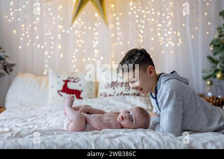 Glückliche Familie, neugeborenes Baby und ältere Brüder, Mutter zu Hause zu Weihnachten Stockfoto