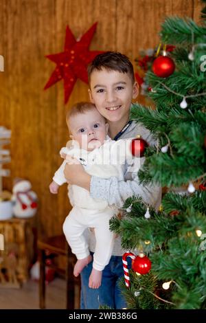 Glückliche Familie, neugeborenes Baby und ältere Brüder, Mutter zu Hause zu Weihnachten Stockfoto