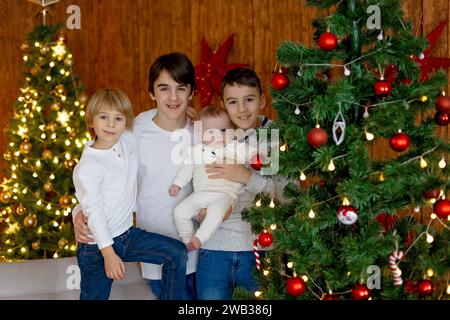 Glückliche Familie, neugeborenes Baby und ältere Brüder, Mutter zu Hause zu Weihnachten Stockfoto